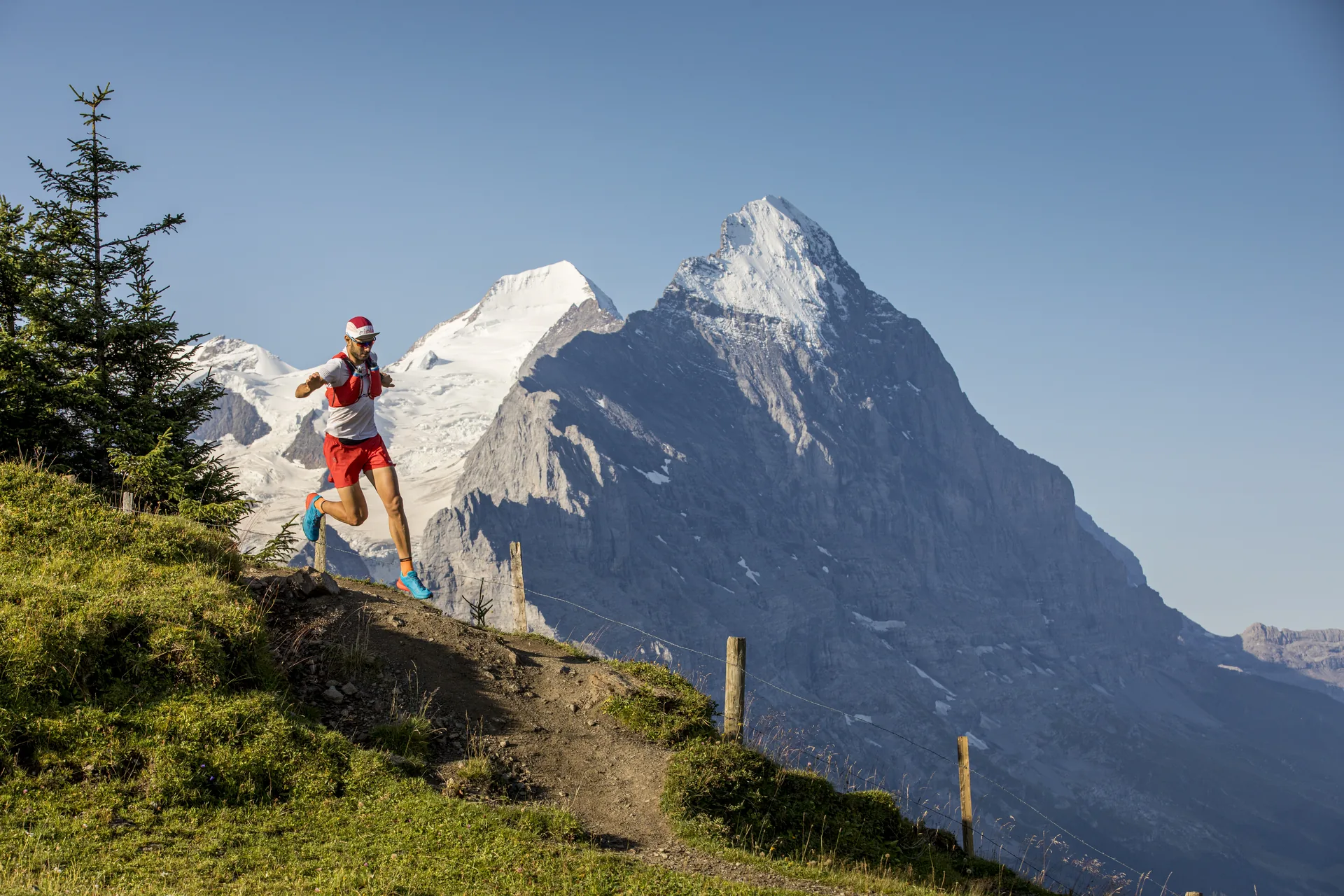 Trailrunner läuft bergauf, Eiger im Hintergrund